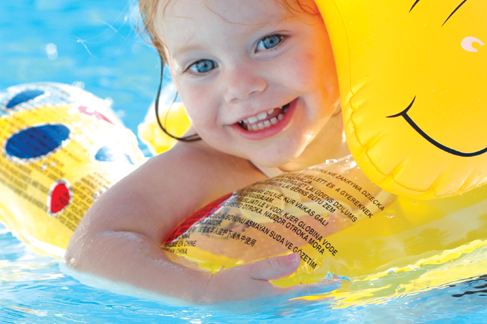 Little girl having fun in clean swimming pool water.